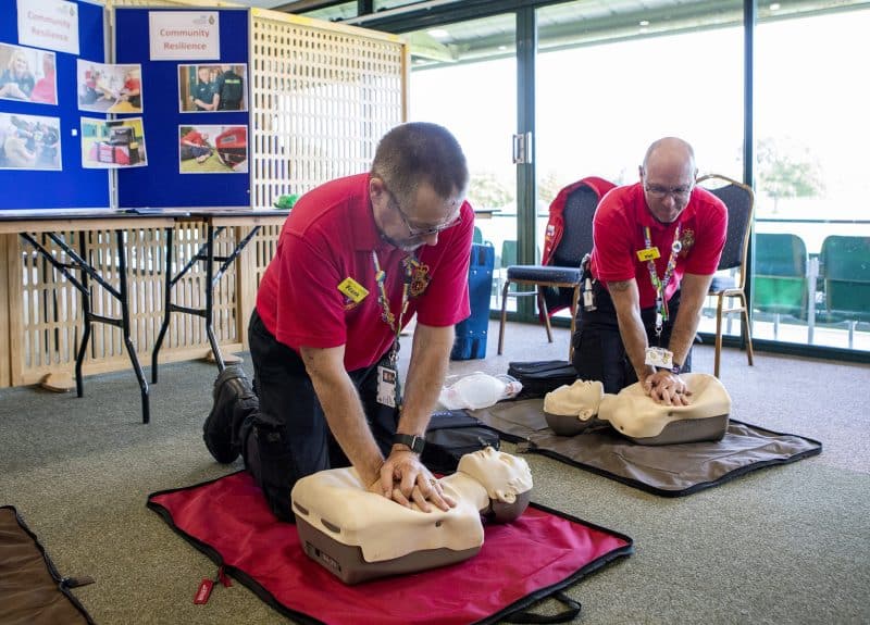 Two men performing CPR on dummies.