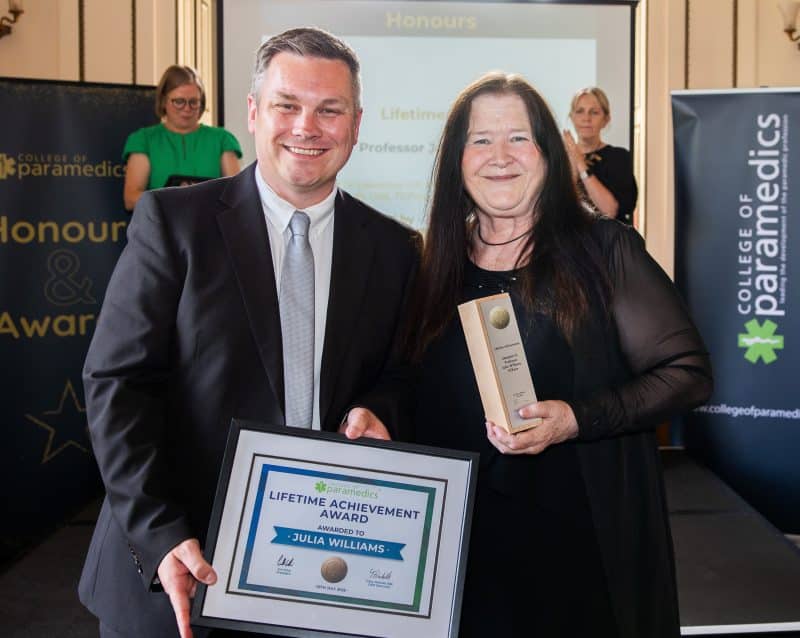College president Jon Price standing next to Julia Williams and handing her the Lifetime Achievement certificate