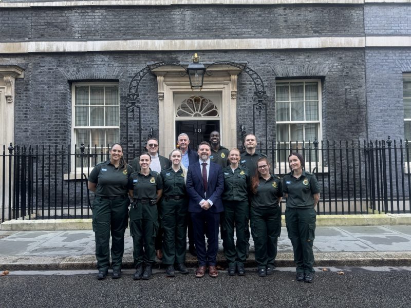 Ambulance colleagues standing outside Downing Street with patient and MET Police Officer.