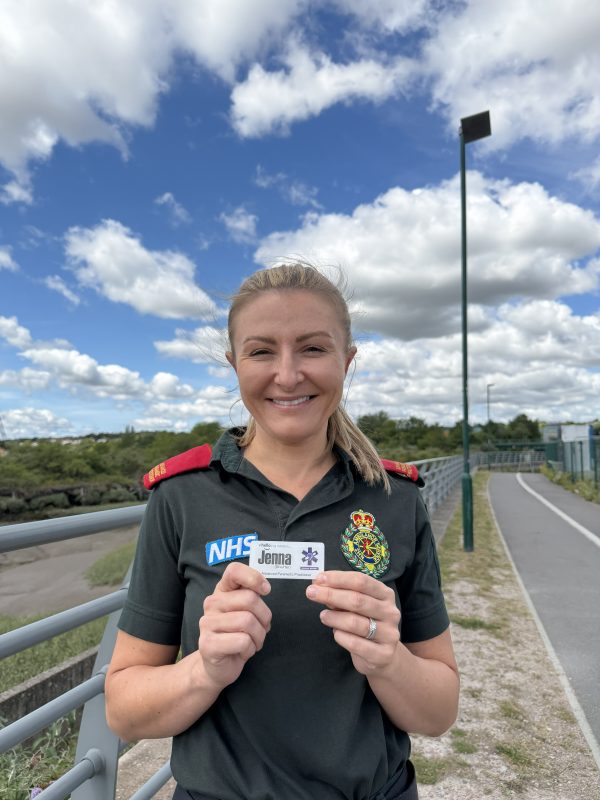 Female in green uniform holding a badge