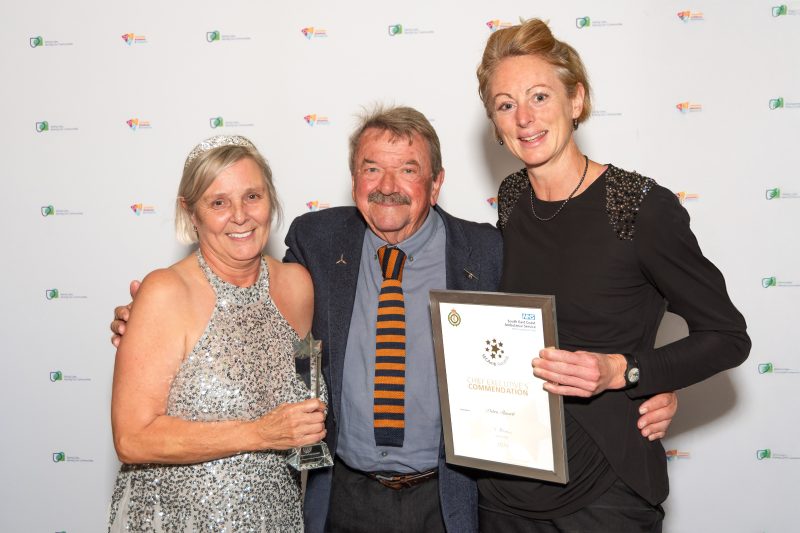 Award Recipient, Debra holds her award stood next to Bill whose life saved and Managing Director Jen who presents her certificate to her