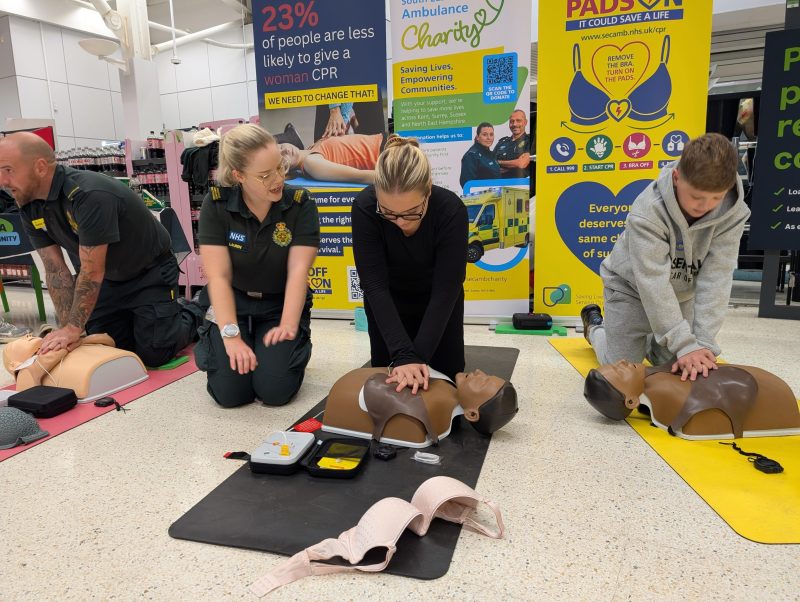 SECAmb ambulance staff teaching members of the public CPR in Asda superstore.