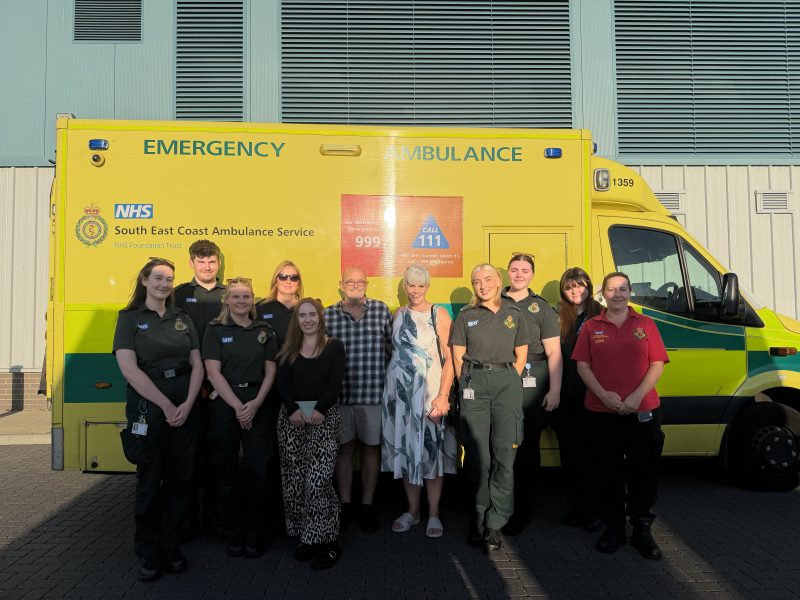 Group of people standing in front of an ambulance